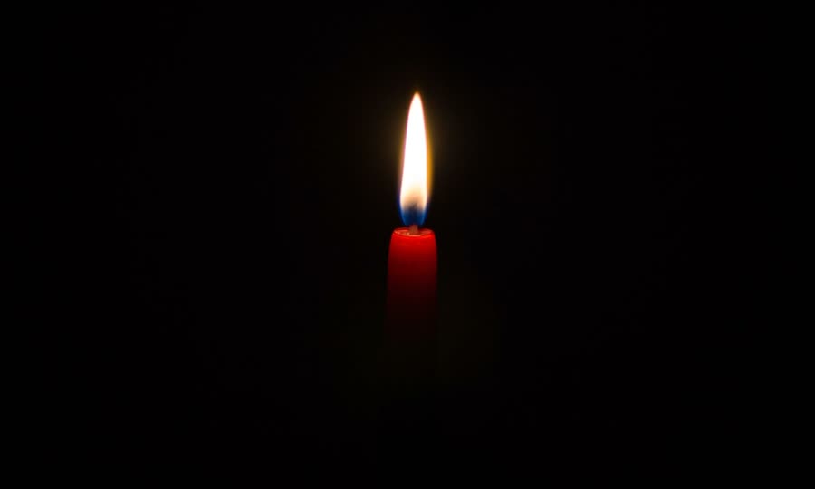 Single candle burning in the dark