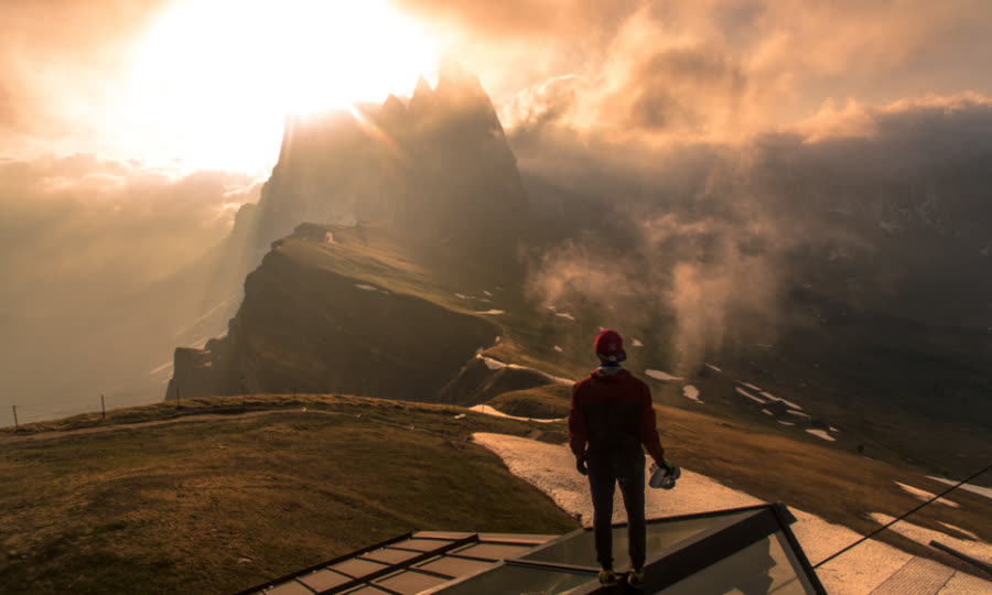 Hiker standing on a summit at sunset